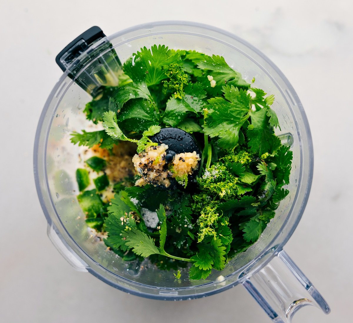 All the ingredients in the cilantro lime sauce being added to a food processor.
