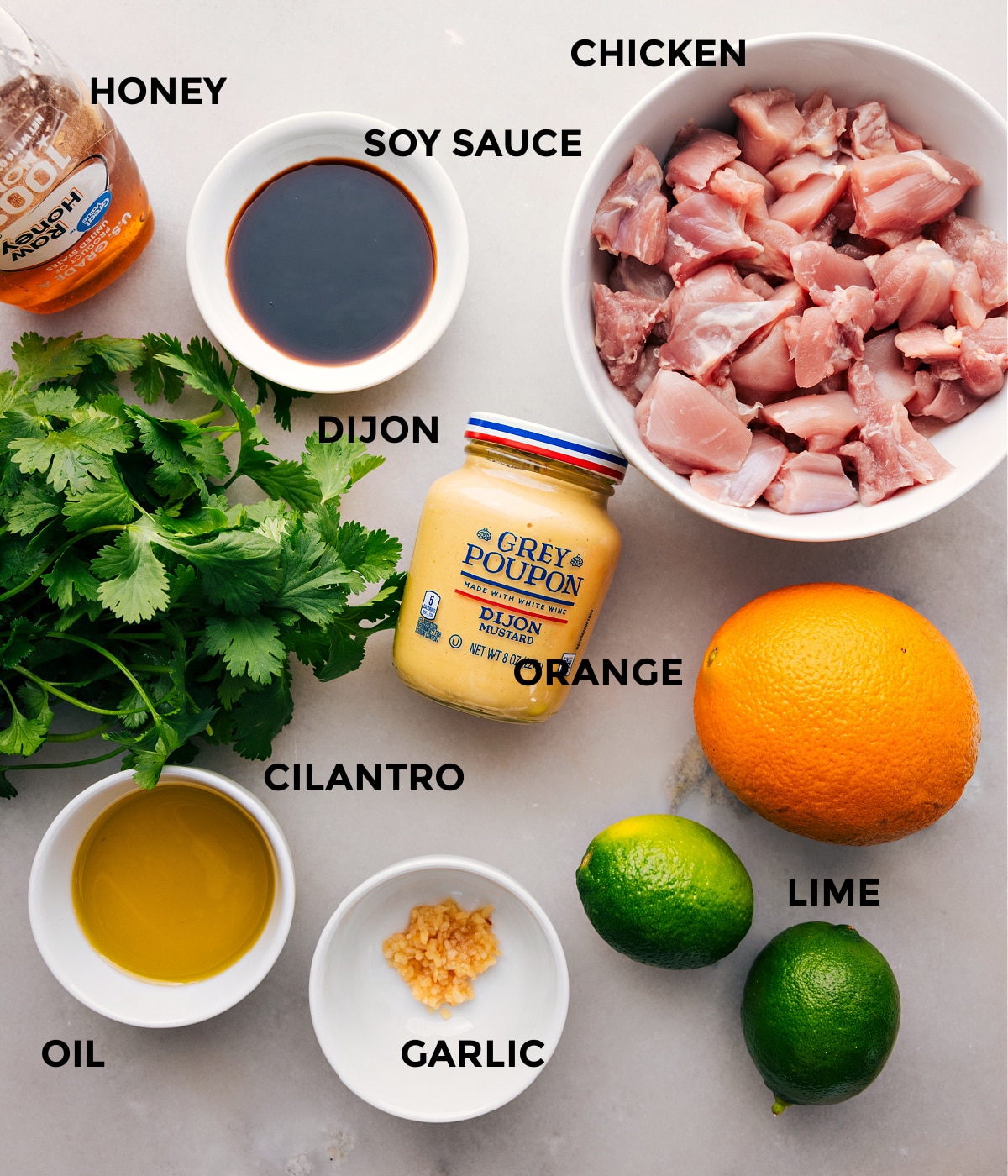 All the ingredients for this recipe are prepped and ready to go—including the meat, soy sauce, honey, Dijon, orange, cilantro, garlic, and lime—for easy assembly.