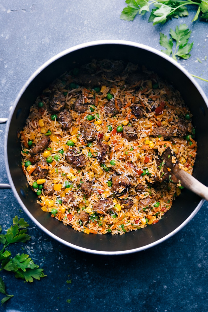 This One Pot Meatballs and Rice is downright delicious! Perfectly tender mini meatballs with fluffy rice, loads of veggies, and a spectacular spice blend. Sure to be a hit with kids and adults alike! Recipe via ChelseasMessyApron #dinner #quick #easy #comfortfood #familyfriendly #kidfriendly #meatballs #rice Overhead image of the meatballs and rice