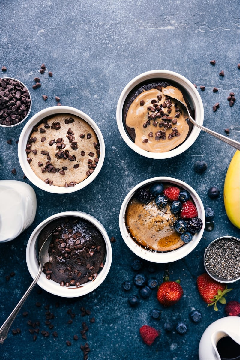 TikTok Baked Oats are a viral sensation -- blend oats with a few other ingredients and bake it into a cake-like breakfast full of good-for-you ingredients! Today we're sharing 4 different versions of TikTok oats -- a plain version (jazz up with fresh berries!), double chocolate, chocolate peanut butter, and chocolate-chip cookie. Recipe via chelseasmessyapron #treat #dessert #best #quick #breakfast #brunch #healthy #tiktok #baked #oats Overhead image of the Tiktok Baked Oats