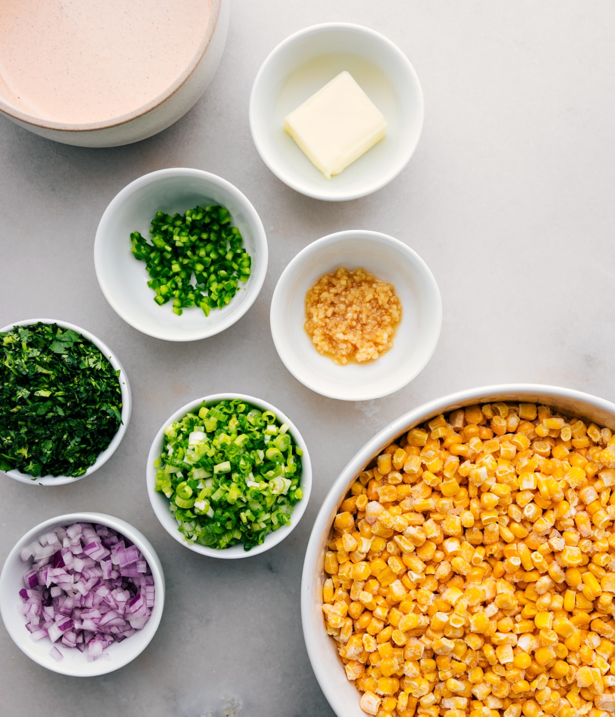Ingredients in this Mexican street corn dip placed in bowls to easily assemble.