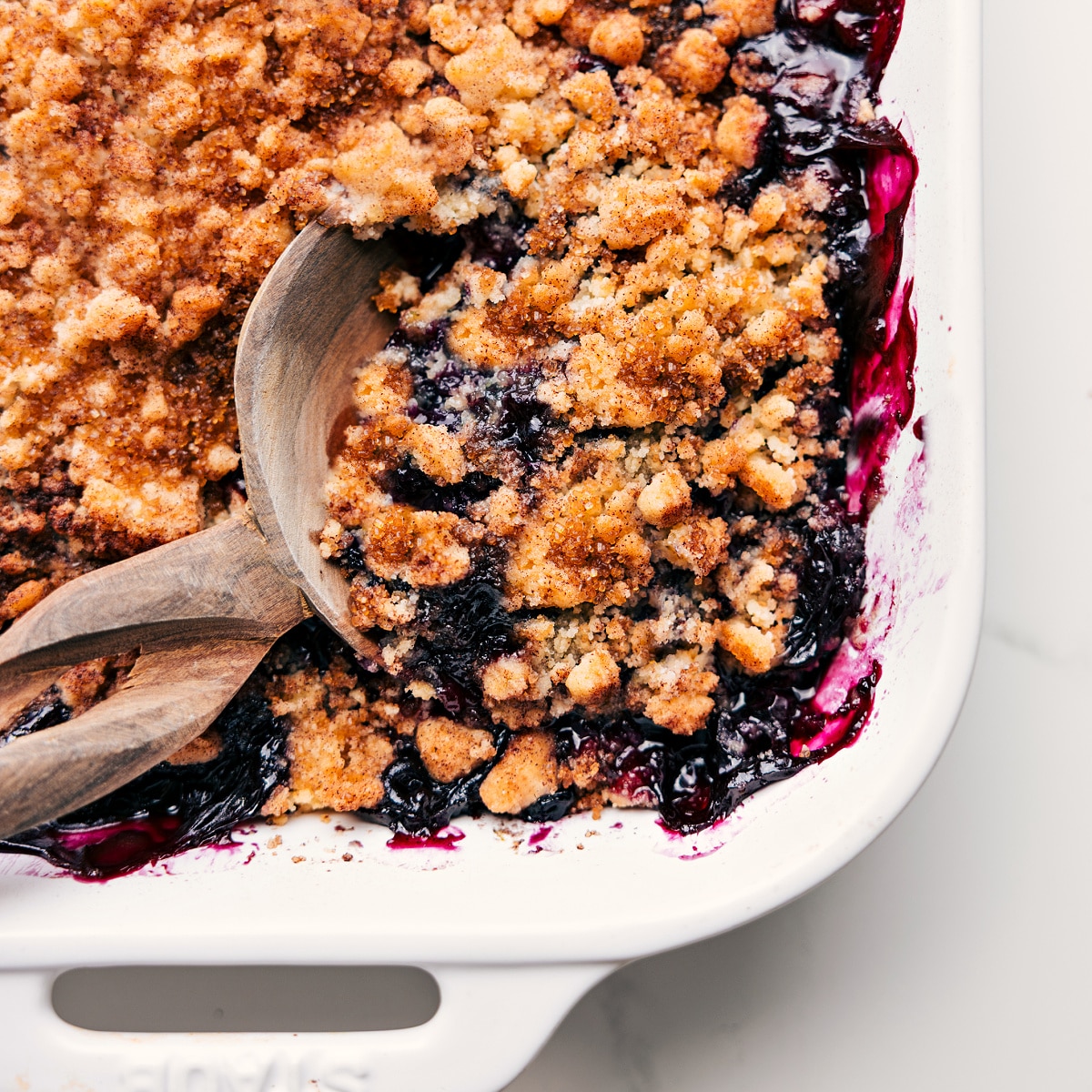 Freshly baked blueberry cobbler with a spoonful being served from the dish.