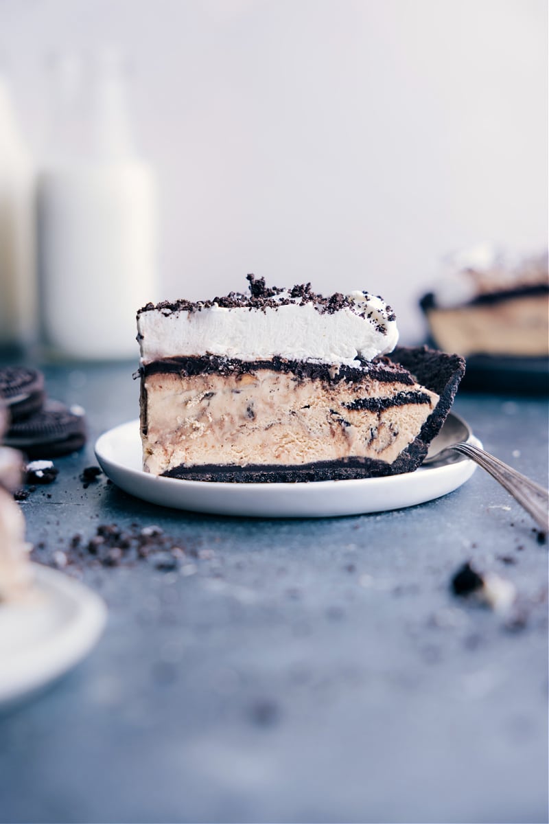 Mississippi Mud Pie is such a favorite for kids and adults alike! We start with a sweet Oreo cookie crust that is topped with hot fudge, coffee-flavored (or chocolate) ice cream, one more layer of fudge, and then creamy whipped topping to finish things off. Recipe via ChelseasMessyApron #dessert #best #quick #easy #simple #treat #quick #nobake #crust #familyfriendly #kidfriendly #mississippi #mud #pie Image of a slice of the Mississippi Mud Pie on a plate