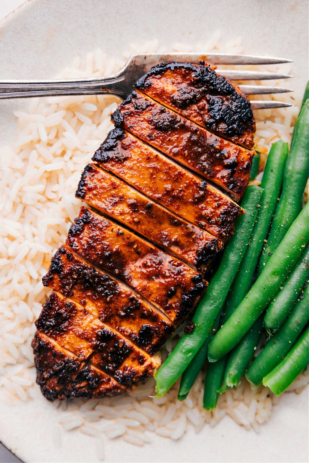 Easy Blackened Chicken recipe over a bed of rice with green beans on the side.