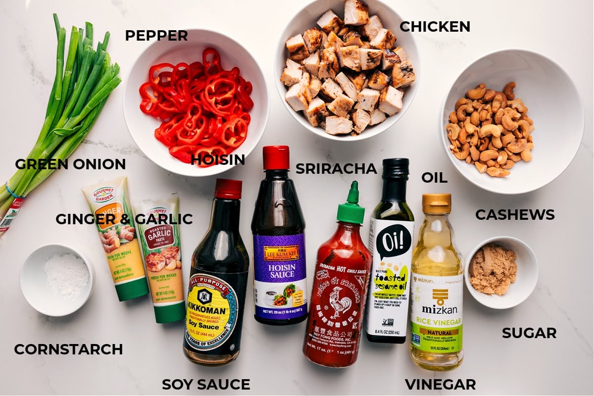 Ingredients to Make Cashew Chicken All the ingredients in this recipe prepped out for easy assembly including the green onion, cornstarch, ginger, garlic, soy sauce, sriracha, oil, vinegar, sugar, cashews, chicken, and peppers.