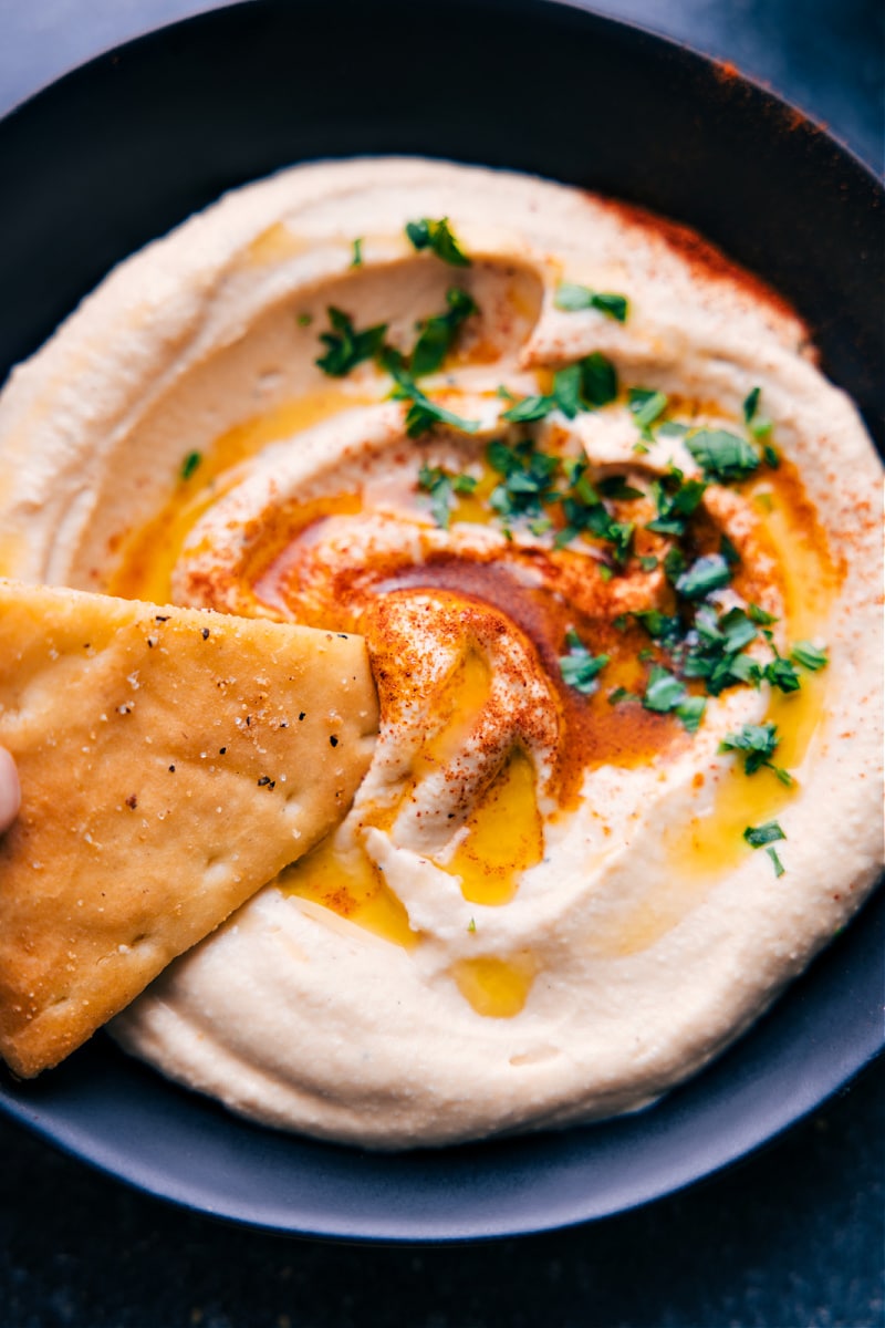 Up-close view of a cracker scooping up some Hummus