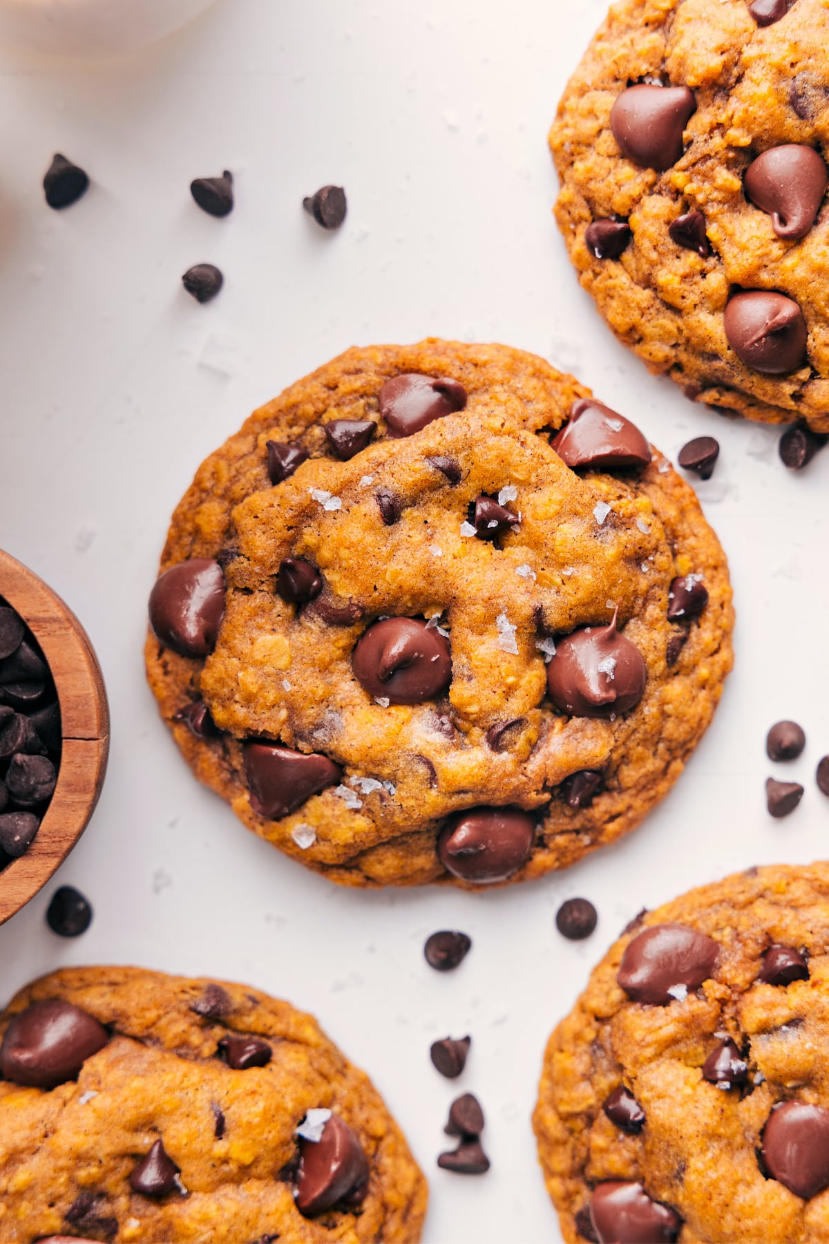 Simple-to-make Pumpkin Oatmeal Chocolate Chip Cookies with crisp edges, a soft, chewy center, and plenty of chocolate! Plus, all the tips and tricks you need are written out to guarantee successful cookies that could rival any bakery! Recipe via chelseasmessyapron #dessert #best #quick #easy #simple #treat #fallbaking #fall #pumpkin #oatmeal #chocolatechip #cookies Pumpkin oatmeal chocolate chip cookies fresh from the oven and topped with flaky sea salt.