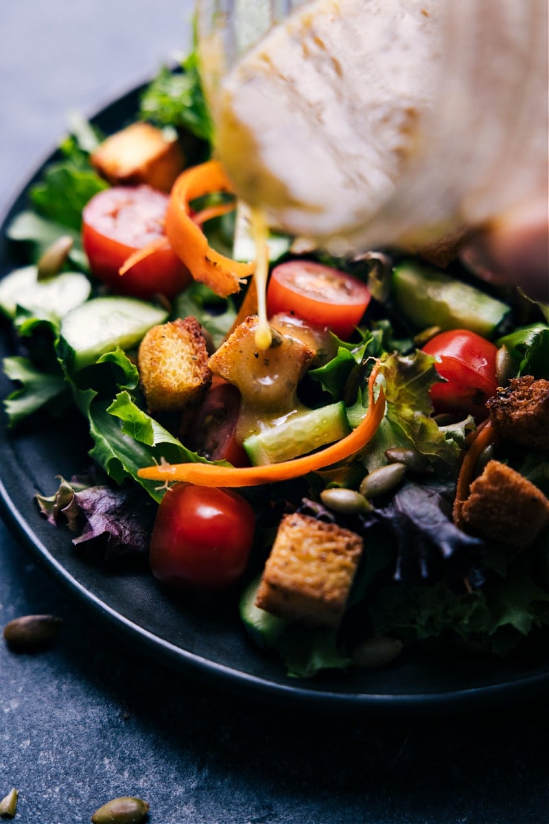 View of Vinaigrette being poured over a salad