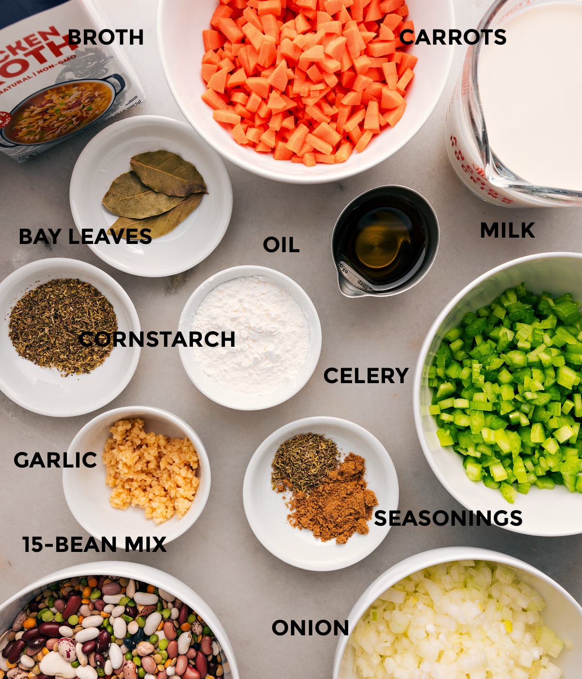All the ingredients are prepped for easy assembly—veggies, milk, bay leaves, beans, garlic, cornstarch, seasonings, and broth.