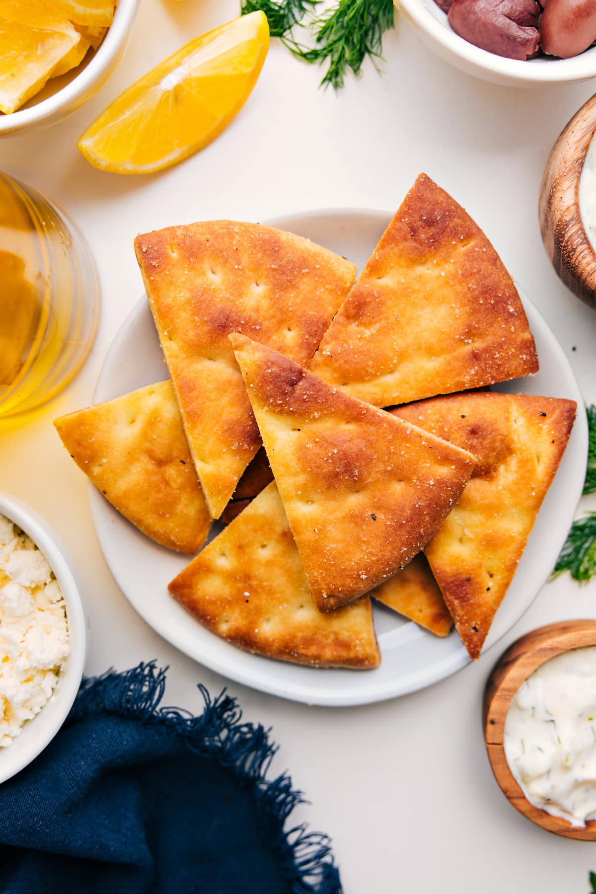 Super Simple Homemade Pita Chips Pita Chips Recipe served on a plate, sprinkled with salt, and ready to enjoy.