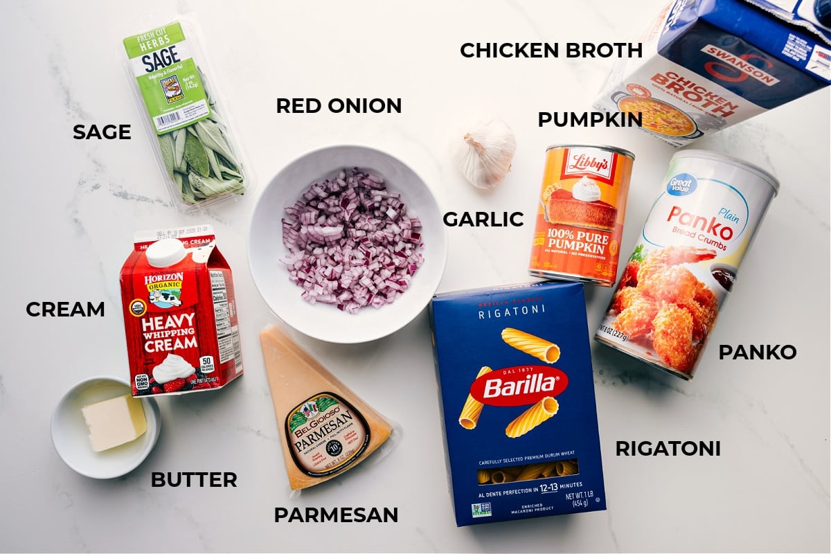 All the ingredients in this recipe prepped for easy assembly, including butter, cream, parmesan, sage, red onion, garlic, rigatoni, panko, pumpkin, and broth.
