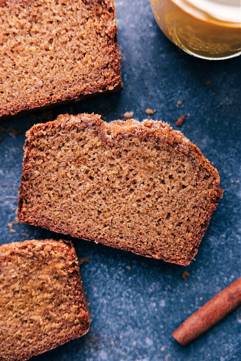 Homemade Applesauce Bread is ultra moist, warmly spiced, and completely delicious. This bread has an entire cup of applesauce in the batter, giving it a strong apple flavor and wonderful texture. Add some sugar to the top of the batter before baking for the best crunchy topping. Recipe via chelseasmessyapron #dessert #best #quick #easy #simple #healthy #breakfast #brunch #quickbread #quickbreads #applesauce #bread Up-close overhead image of Applesauce Bread ready to be enjoyed