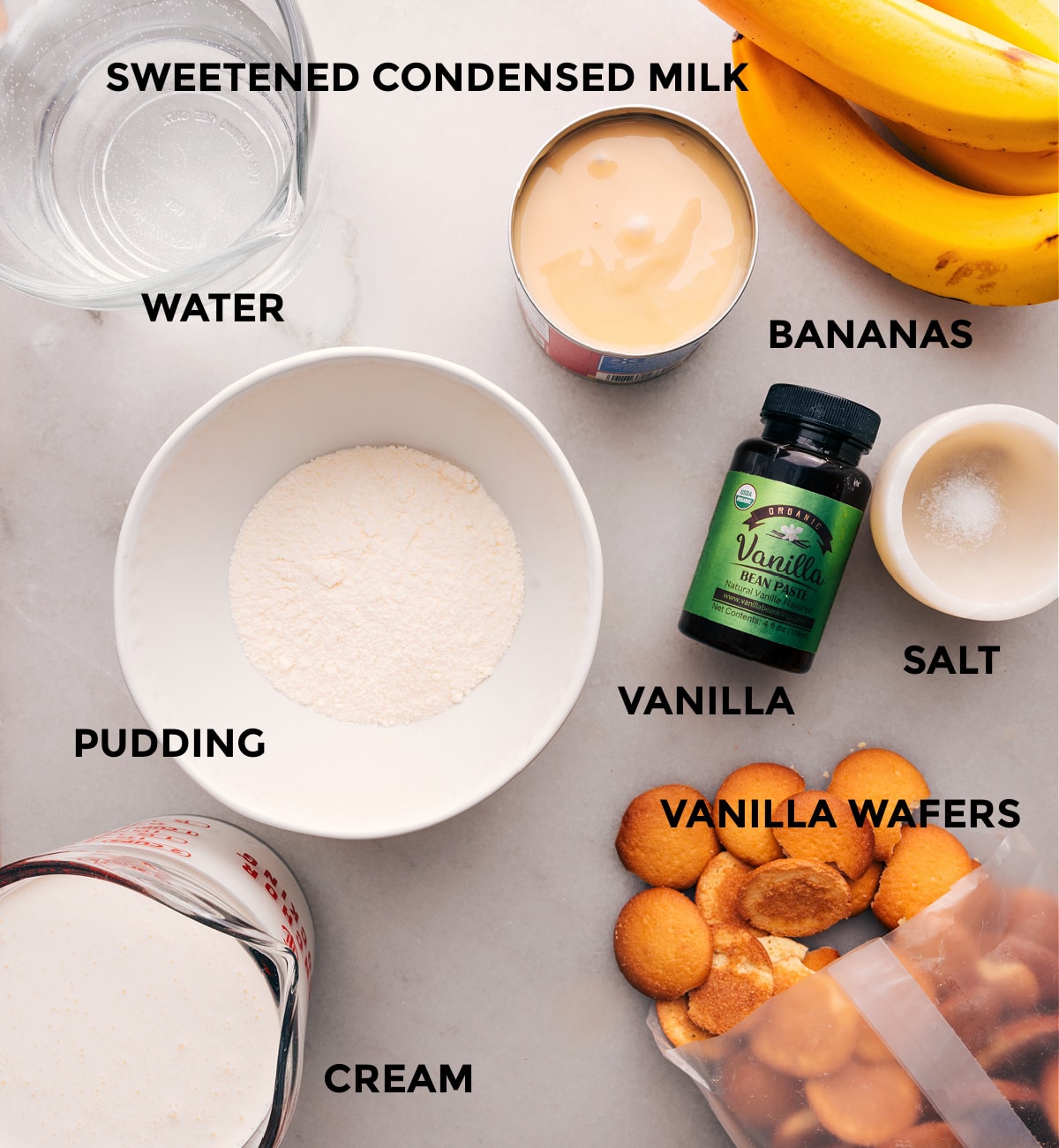 An array of ingredients used to create this dessert, including sweetened condensed milk, vanilla wafers, cream, vanilla, and more, ready to be combined into a delectable dessert.