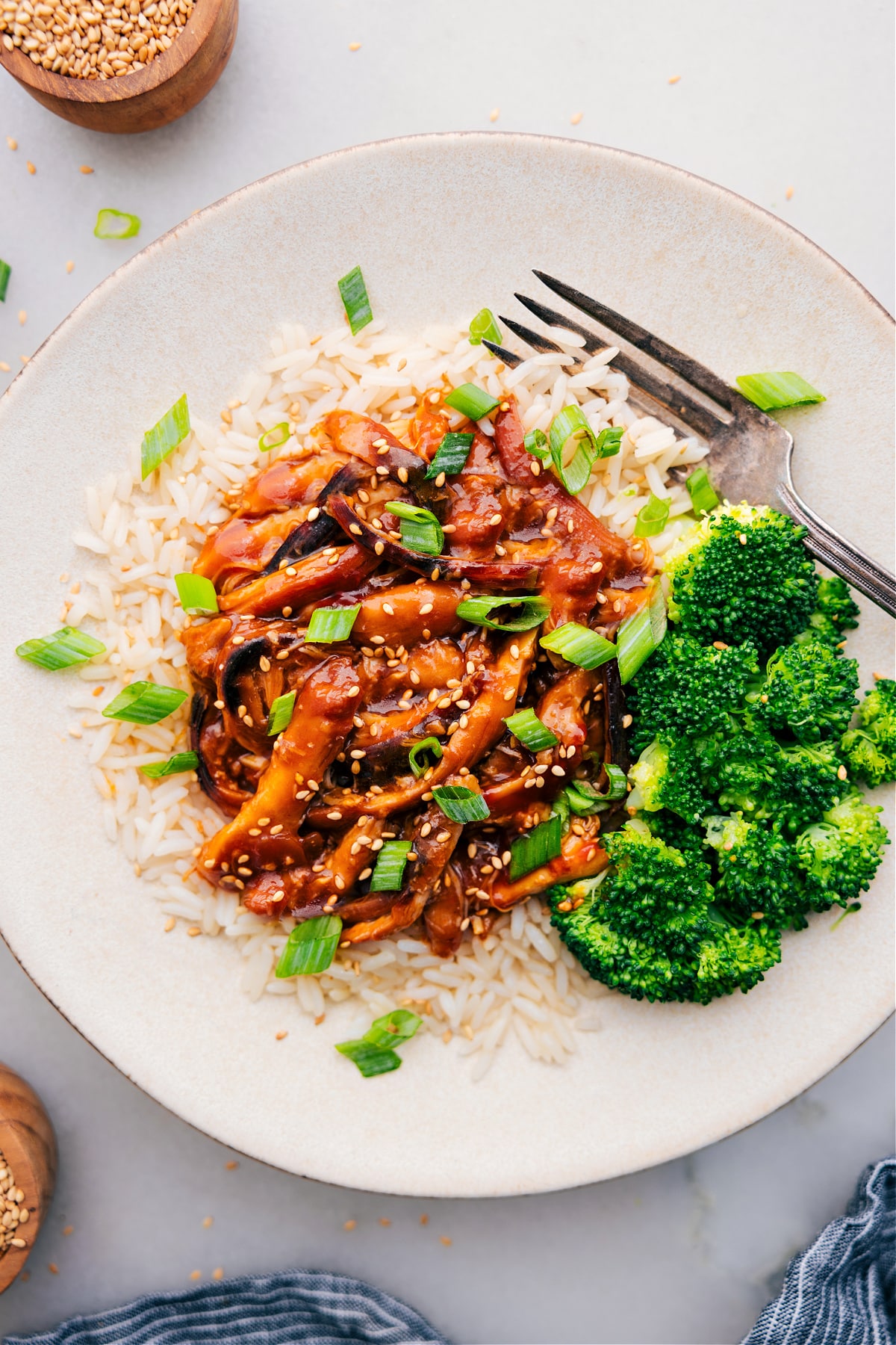 The Best Honey Garlic Chicken Thighs Recipe Honey Garlic Chicken Thighs served on a bed of rice, accompanied by broccoli on the side and topped with fresh green onions.