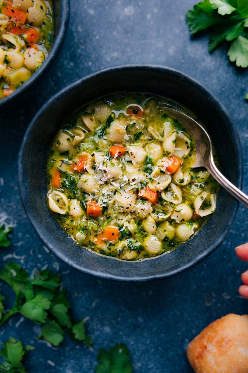 If you need a comforting and flavorful soup to warm you up, this Vegetable Pasta Soup is the perfect choice. Filled with a variety of vegetables and packed with flavor, this soup is sure to satisfy your cravings. We've also added a special parsley, oil, and almond infusion to take the flavor to the next level. Trust us, you won't be able to resist seconds (or even thirds) of this deliciousness. So go ahead and give this hearty, herb-packed soup a try – your taste buds (and stomach) will thank you! Recipe via chelseasmessyapron #dinner #quick #easy #simple #comfortfood #familyfriendly #kidfriendly #winterrecipes #vegetable #pasta #soup Overhead image of the Vegetable Pasta Soup