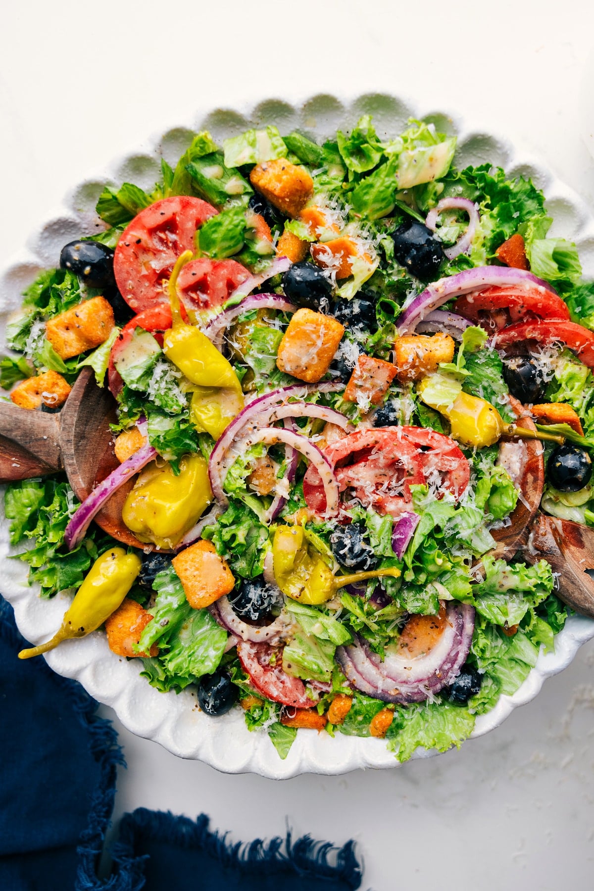 Olive Garden salad recipe tossed in a bowl with dressing.