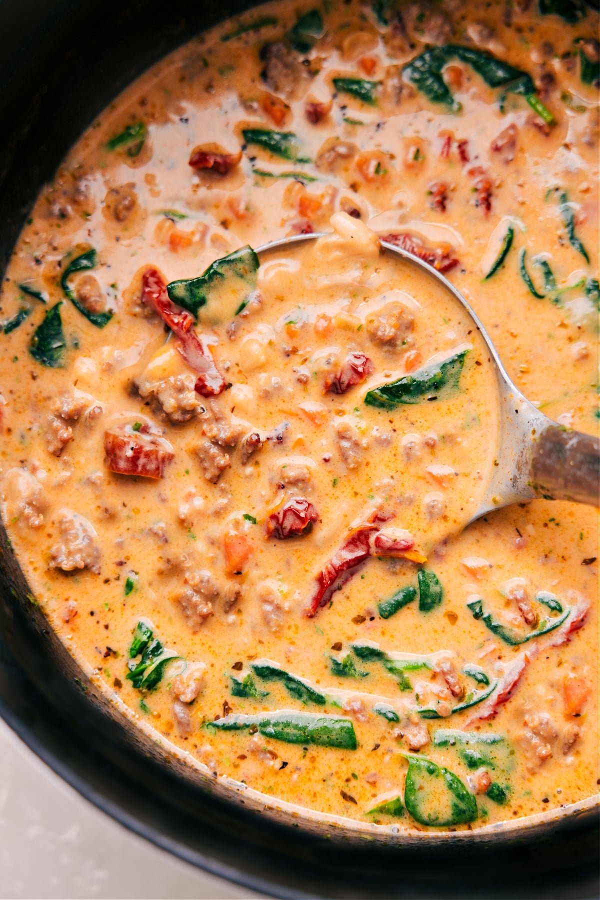 The Best Tuscan Soup Recipe Tuscan Soup in a pot with a ladle scooping it up.