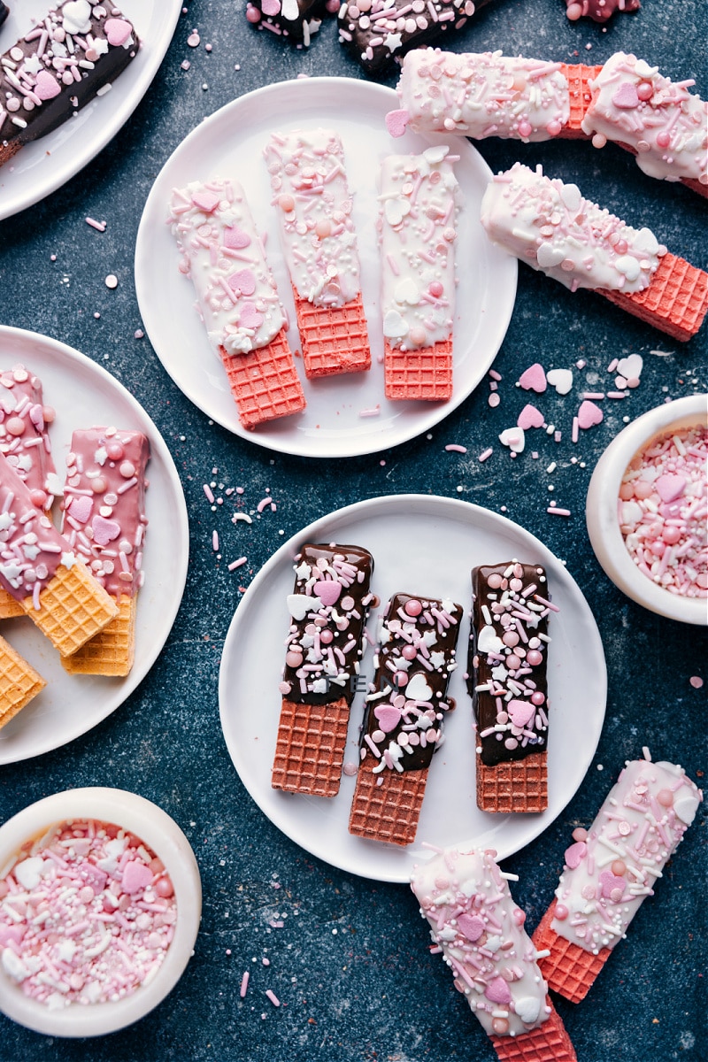 Indulge in a sweet and satisfying treat with our delicious Chocolate-Covered Wafers recipe! These bite-sized treats are the perfect combination of crunchy, sweet wafers and creamy, rich chocolate. Whether you choose vanilla, chocolate, or strawberry wafers, or a mix of all three, this recipe is sure to satisfy your sweet tooth. Topped with festive sprinkles, these little delights make for an eye-catching addition to any celebration or just as a sweet snack to enjoy on any day. Recipe via chelseasmessyapron #dessert #best #quick #easy #simple #familyfriendly #kidfriendly #snack #valentinesday #valentinestreat #chocolatecovered #wafers Overhead image of Chocolate Covered Wafers