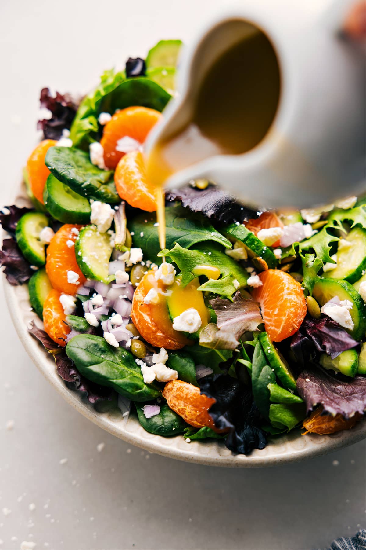 The Best White Balsamic Vinaigrette Drizzling White Balsamic Vinaigrette over a salad.