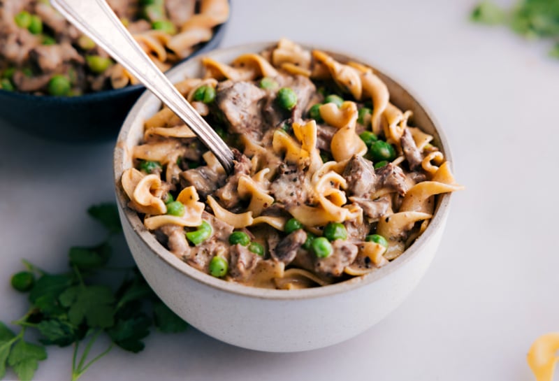 Bowl of saucy noodles and beef with a fork digging in
