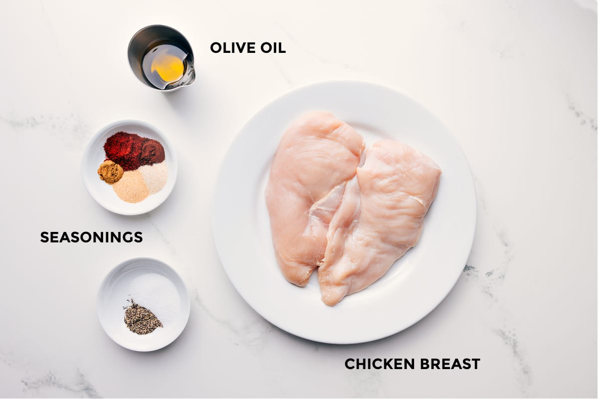 Ingredients in this recipe prepped out for easy assembly including the olive oil, seasonings, and chicken.
