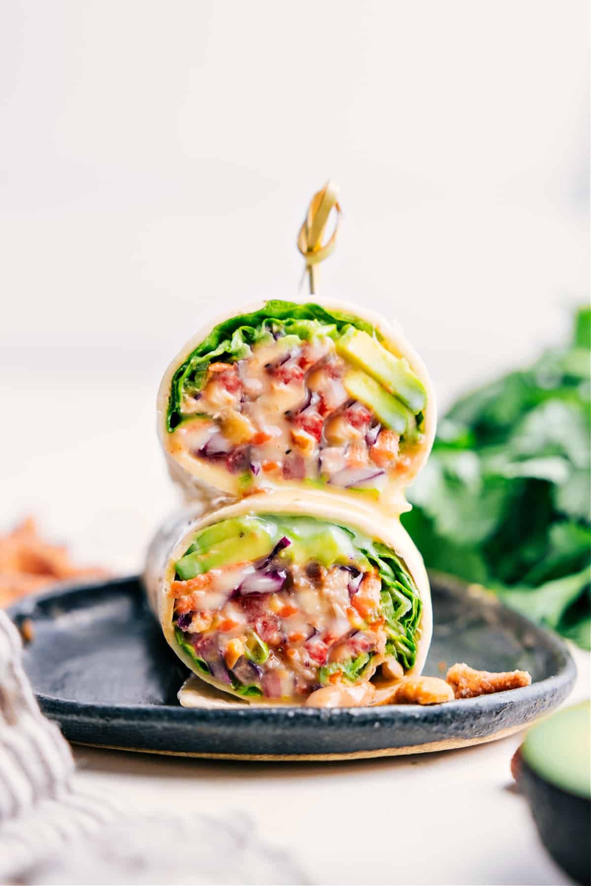 Cashew Chicken Wraps stacked on a plate, ready to eat.