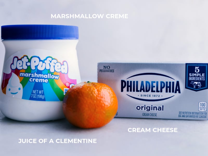 Ingredient shot of the fruit dip-- image of marshmallow creme, clementine, and cream cheese