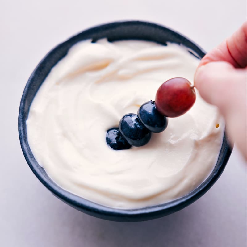 Image of the Fruit Rainbow Tray being dipped in the dip