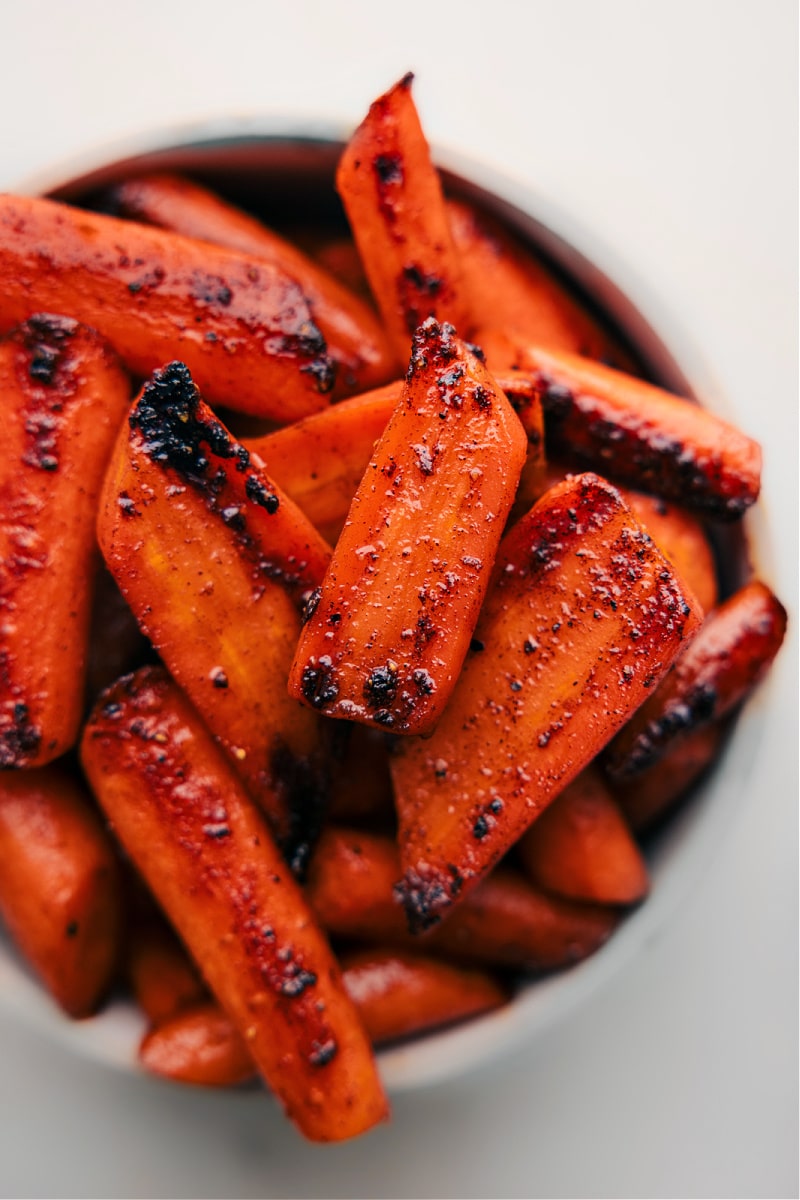 Up-close overhead image of the Brown Sugar Roasted Carrots in a bowl, ready to be enjoyed