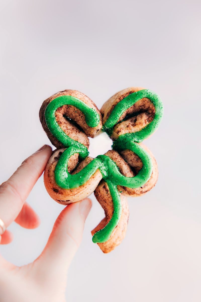 Shamrock cinnamon roll being held up