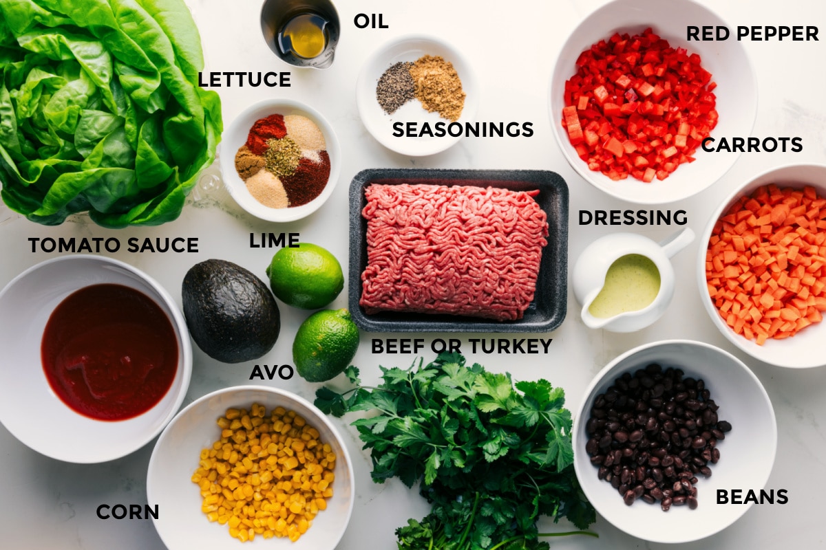 Ingredients In Turkey Lettuce Wraps All the ingredients in this recipe prepped out for easy assembly including the lettuce, tomato sauce, corn, avocado, seasonings, limes, beef or turkey, beans, dressing, carrots, red pepper, and oil.