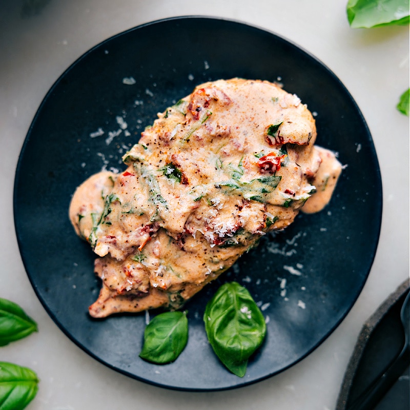 Overhead view of Marry Me Chicken on a plate, garnished with basil leaves