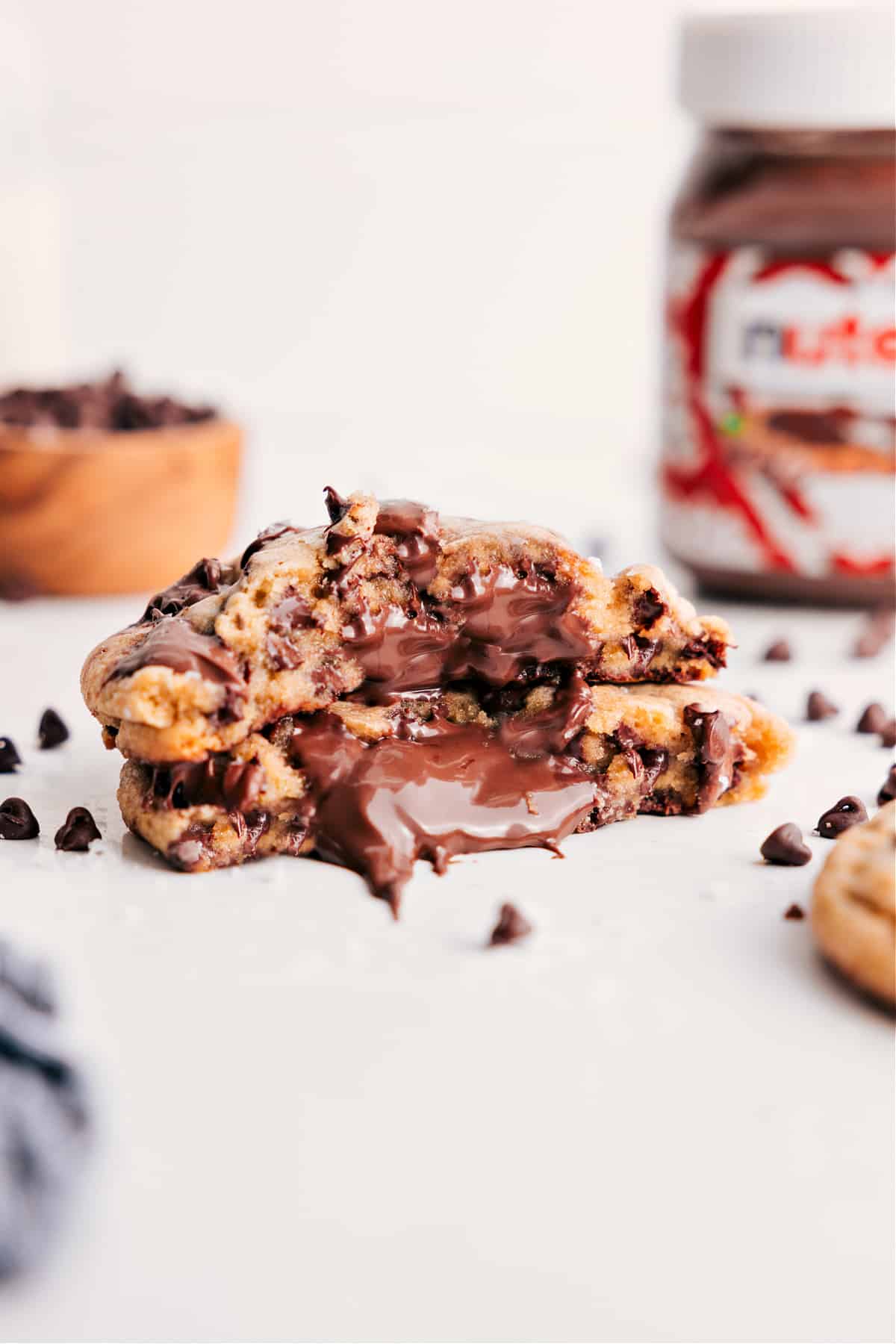 Nutella Stuffed Chocolate Chip Cookies For The True Cookie Lovers Nutella Stuffed Chocolate Chip Cookies broken in half to show the Nutella filled center.