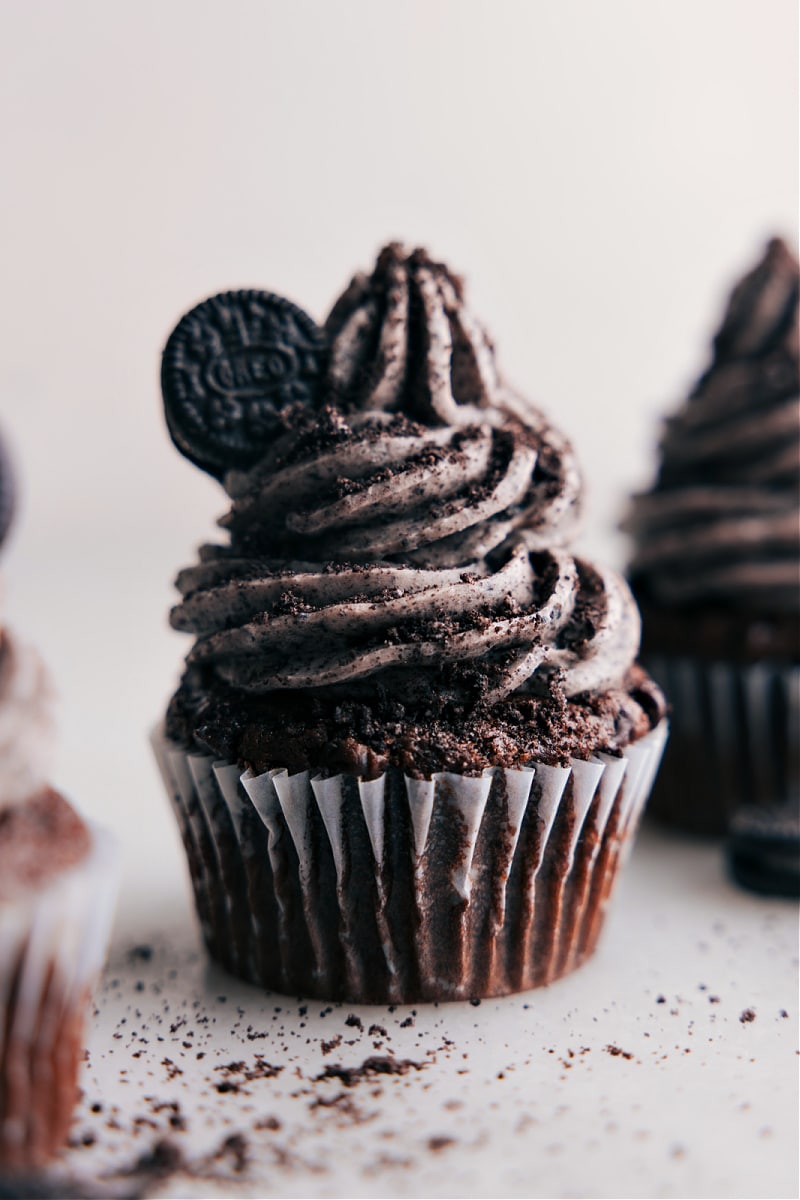 Oreo Frosting! It's a sweet and creamy dream come true! Super easy to whip up, it'll turn your cakes and cupcakes into a hit. Give it a go, and watch as everyone comes back for seconds! Recipe via chelseasmessyapron #dessert #best #quick #easy #simple #treat #birthday #cupcakes #cake #oreofrosting #frosting Image of a cupcake with Oreo Frosting ready to be served