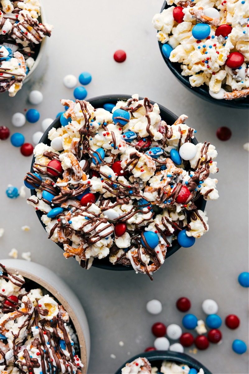 The 4th of July is almost here, and we've got a fun, patriotic popcorn mix to get the party started! This 4th of July Popcorn is packed with delicious white chocolate-covered popcorn, crunchy pretzels, and red, white, and blue M&M's. It's super easy to whip up and you can jazz it up with your choice of sprinkles or extra candy. Let the festivities begin! Recipe via chelseasmessyapron #dessert #best #quick #easy #simple #familyfriendly #snack #quick #festive #4thofjuly #popcorn Overhead image of this 4th of July Popcorn