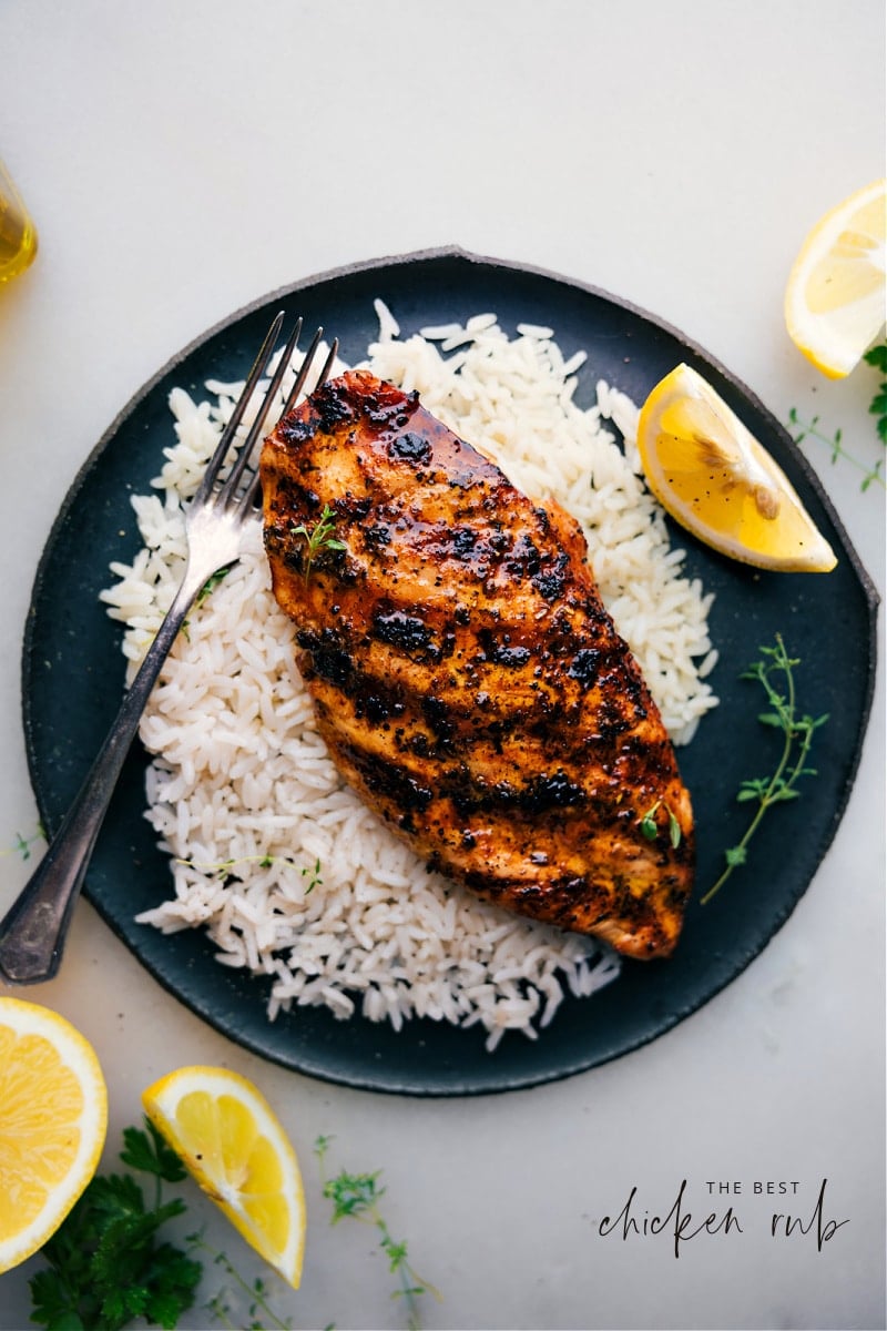 View of a boneless chicken breast on a bed of rice.