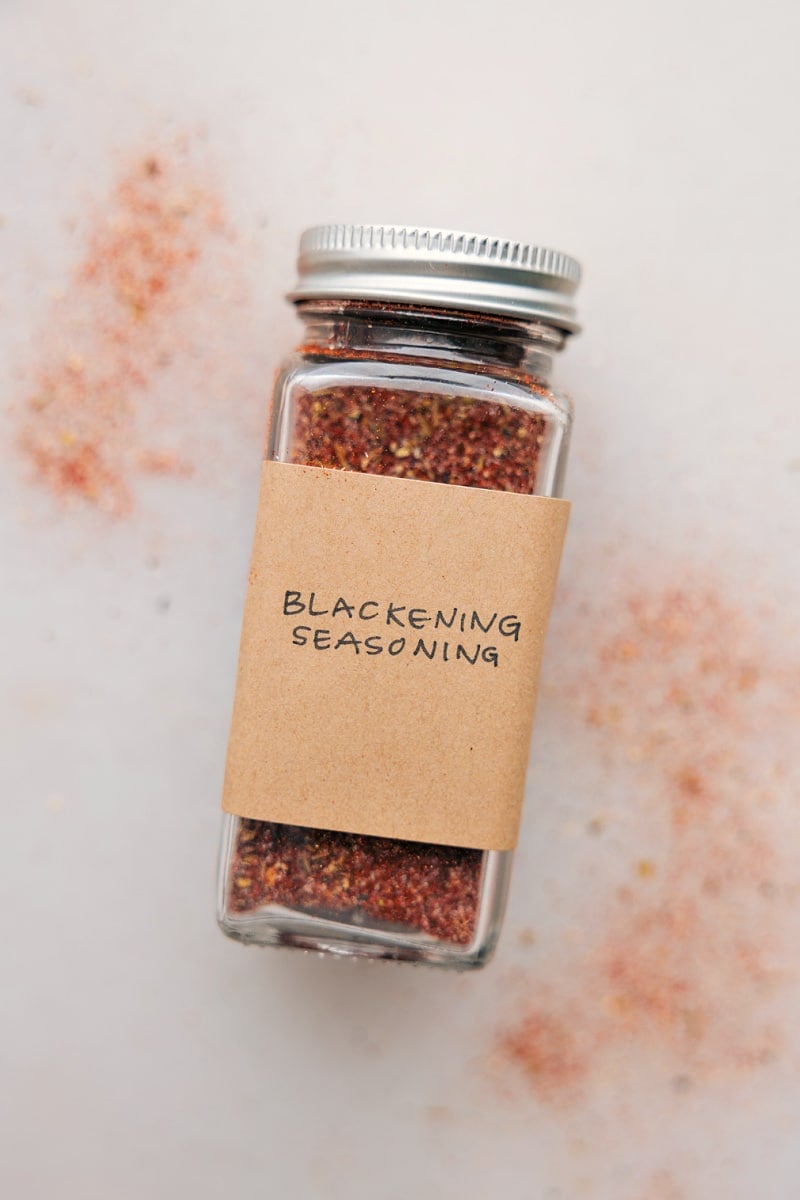 This Blackening Seasoning recipe creates a versatile, smoky, and spicy blend perfect for forming a flavorful crust on grilled or pan-fried dishes. Easily homemade, it combines everyday spices and can be stored for future use, bringing a robust flavor to meats, fish, and vegetables. Recipe via chelseasmessyapron #spice #seasonings #quick #easy #simple #grilling #blackening #seasoning Image of the blackening seasoning in a container