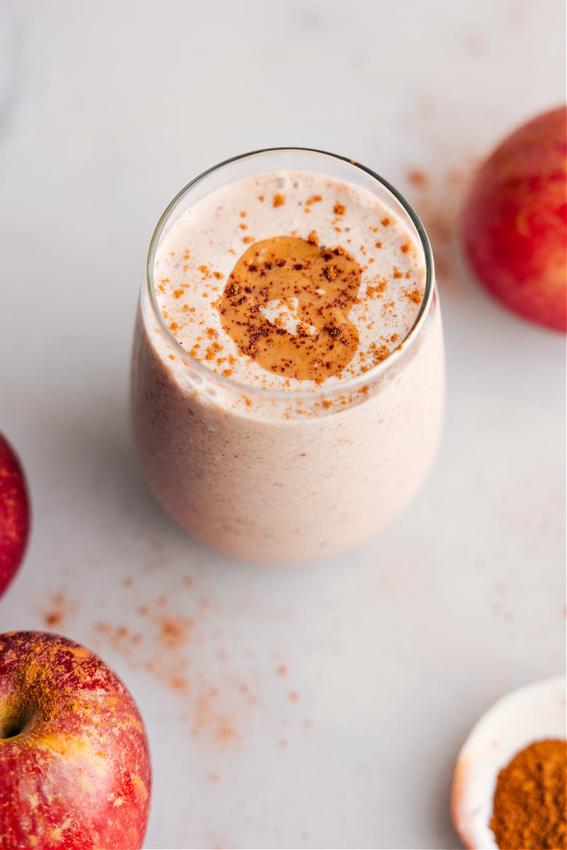Overhead view of the prepared Apple Smoothie, garnished with spices and a drizzle of almond butter
