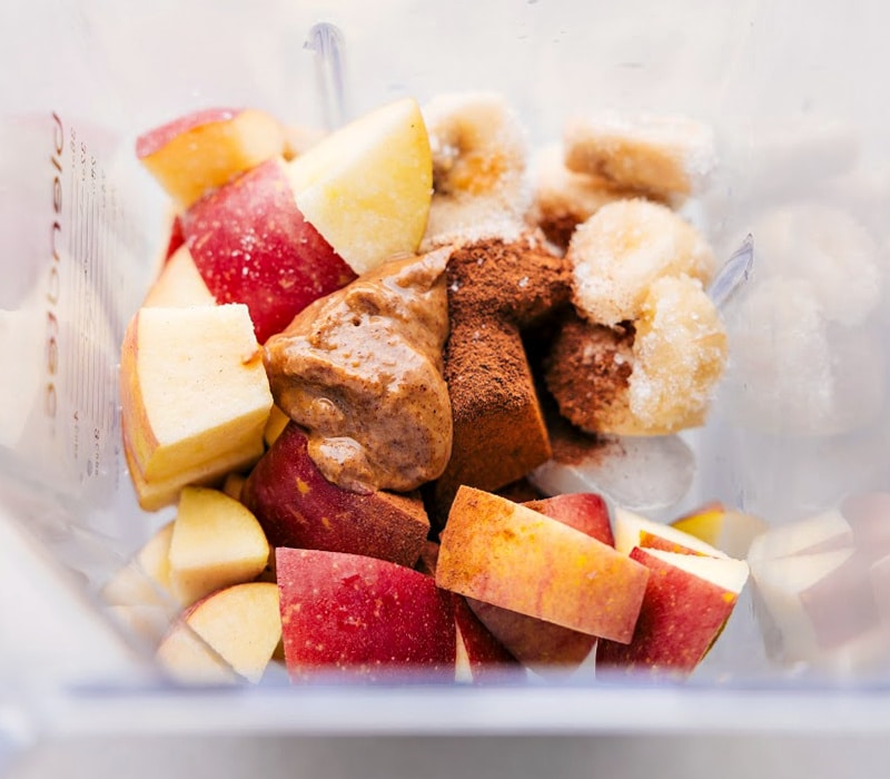 Overhead view of the apples, spices and almond butter in the blender, ready to be processed.