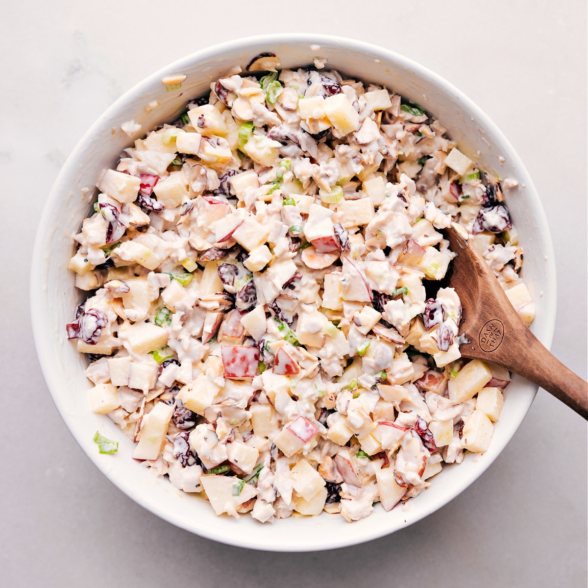 Finished chicken salad with chunks of apple in a bowl, ready to serve.