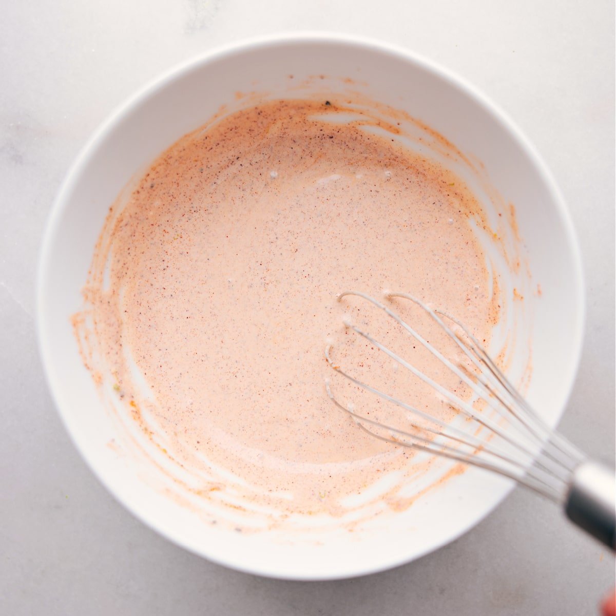 Whisk blending creamy ingredients together.