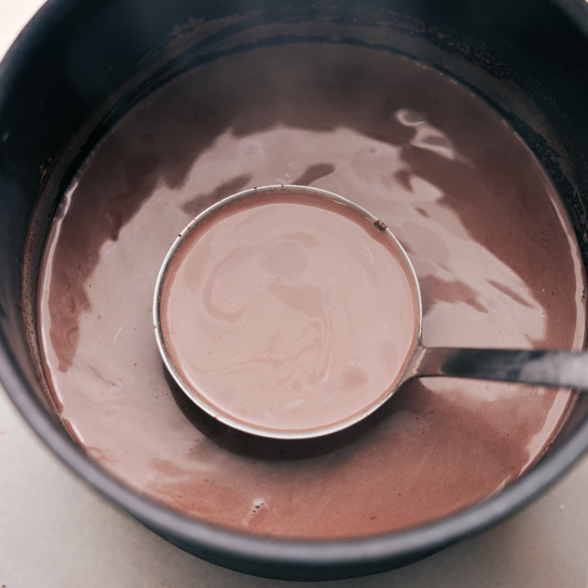 Warm, inviting Mexican Hot Chocolate prepared for pouring into a cup, promising a cozy, flavorful experience.