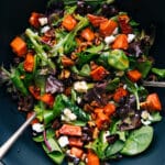 A vibrant bowl of sweet potato salad, featuring diced roasted sweet potatoes mixed with various colorful ingredients.