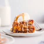 A slice of bread pudding topped with a scoop of ice cream, served warm as a delicious dessert.