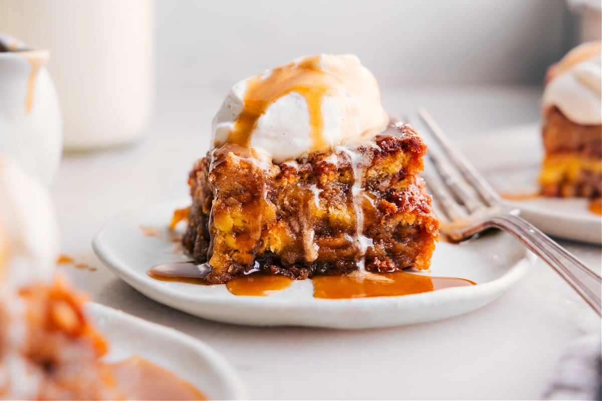 A slice of freshly baked bread pudding, showcasing its delicious interior, topped with a scoop of vanilla ice cream.