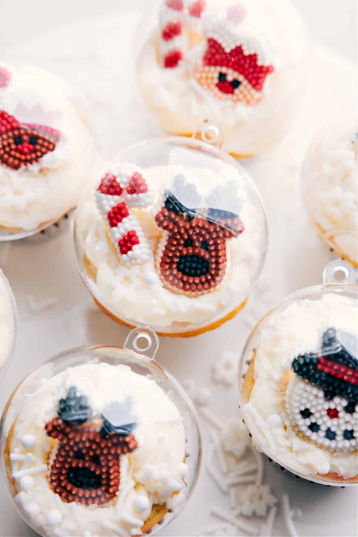 The festive desserts, showcasing adorable reindeer and candy cane toppings, resembling a snow globe in design.