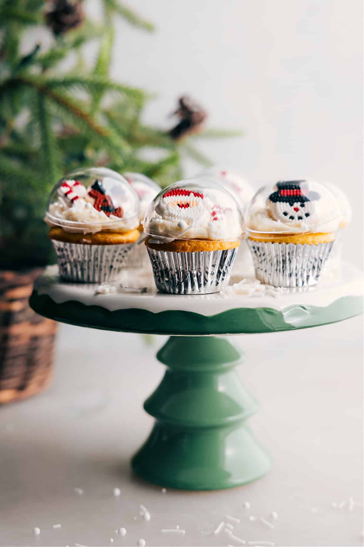Several gorgeous Christmas cupcakes on a stand, decorated to resemble ornaments, creating a beautiful and festive dessert display.