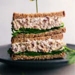 Turkey salad sandwich cut in half, filled with turkey salad and lettuce, prepared and ready to be enjoyed.