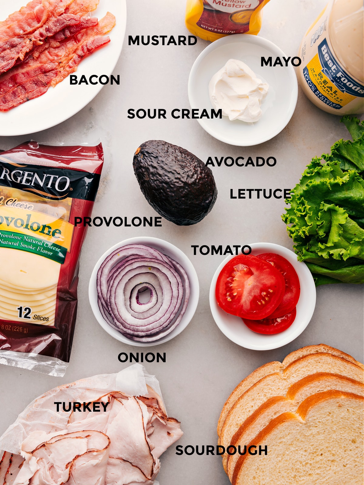 Ingredients used in the recipe including cheese, vegetables, meat, bacon, and mayo.