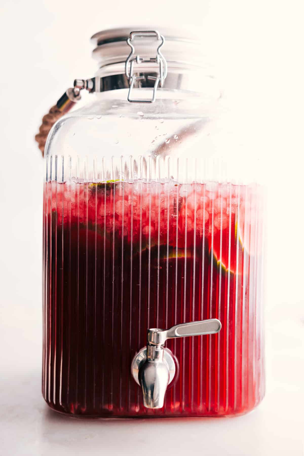 All the ingredients in Christmas Punch in a big dispenser container ready to be served.